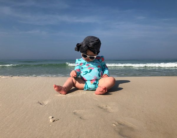 Bebe con gafas en la playa.