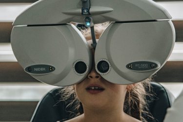 óptico revisa la visión de una niña-