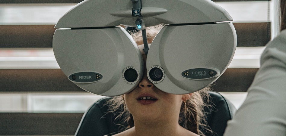 óptico revisa la visión de una niña-