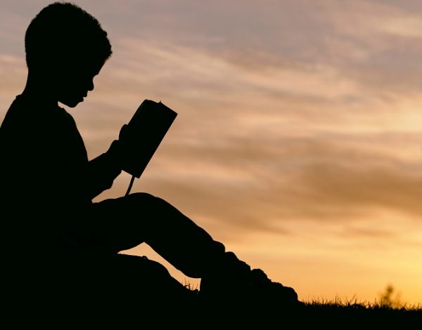 Niño lee al atardecer.